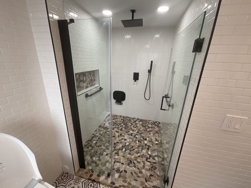 Walk-in shower with frameless glass and pebble floor